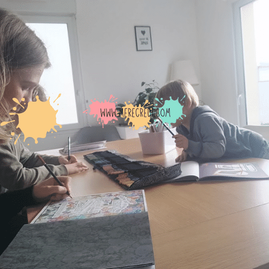 femme et ses enfants en train de colorier, chacun concentré sur son dessin