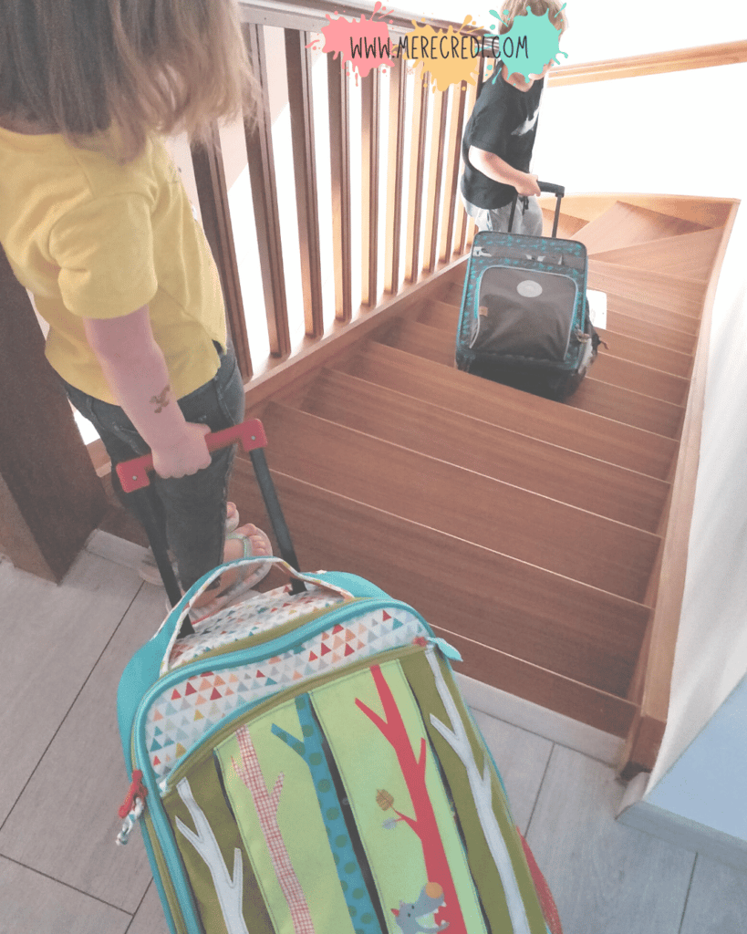 enfants avec chacun leur valise qu'ils ont fait seuls, prêts pour les vacances